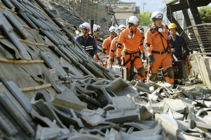 Para petugas pertolongan ketika menyusuri puing-puing akibat gempa.