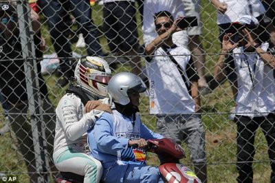 Lewis Hamilton dibonceng ke pit setelah tabrakan pada laga F1 Barcelona, Minggu. (dailymail.co.uk) 