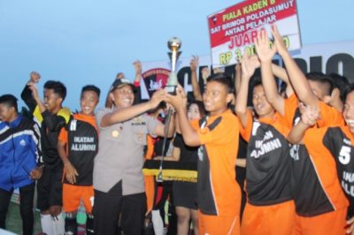 kaden B Brimobdasu Tebingtinggi Akbp. Arke Furman Ambat menyerahkan piala kepada kesebelasan SMAN 2 Tebingtinggi,Senin.  (al)  