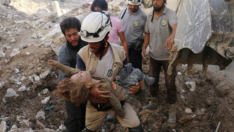 Kelompok “Helm Putih” tampak menyelamatkan seorang anak dari puing bekas hantaman serangan udara. Pihak penyelamat mengatakan bahwa pihaknya juga berulang kali jadi target dalam perang Suriah. (Foto:AFP/Al Jazeera)