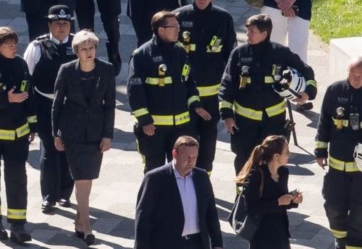 Perdana Menteri Inggris Theresa May berbicara dengan beberapa petugas pemadam saat melakukan peninjauan di lokasi kebakaran. (Foto: Copyright Getty Images/BBC News)