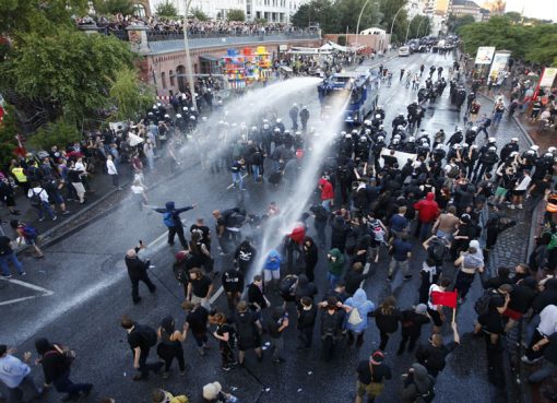 Polisi anti huru hara Jerman menggunakan meriam air, tongkat, dan semprotan merica dalam menghadapi demonstran menentang G20 KTT di Hamburg, Jerman, Kamis (6/7). [Foto: Reuters/Al Jazeera)