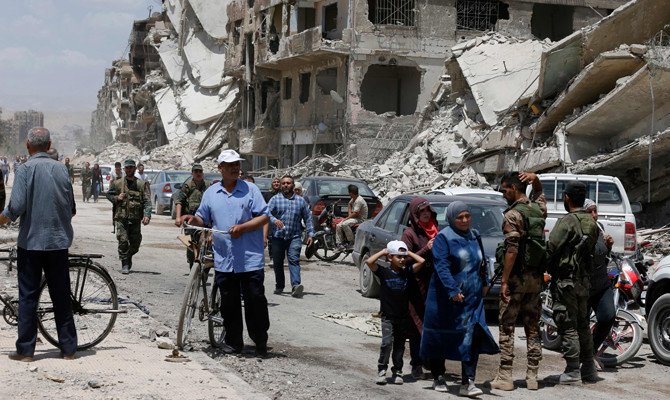 Pasukan pro-pemerintah patrol di Jalan Thalateen di kamp pengungsi Palestina Yarmuk, di pinggiran selatan ibukota Damaskus, yang hancur, ketika warga sipil kembali untuk melihat rumah mereka 24 Mei 2018 lalu. Rezim merebut kamp dan daerah tetangga Tadamun dan Hajar kembali, yang berdekatan dengan al-Aswad pada awal minggu lalu dari kelompok Daesh . (Foto: AFP/Arab News)