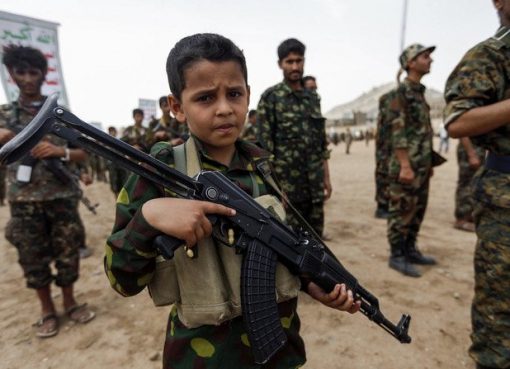 Seorang bocah Yaman berpose dengan senapan serbu Kalashnikov saat berkumpul dengan anggota Houthi lainnya yang baru direkrut di ibukota Sanaa. (Foto: File AFP/Arab News)