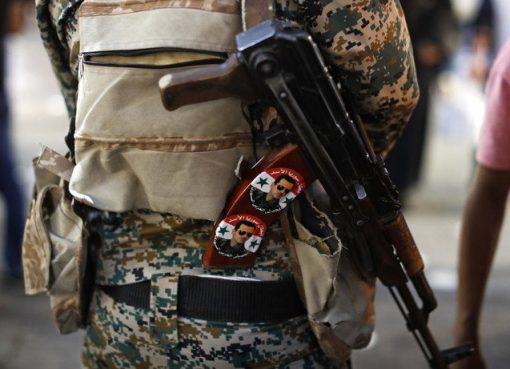 Seorang tentara Suriah memegang senapan AK-47 yang ditempeli stiker Presiden Bashar Assad bertuliskan bahasa Arab yang berbunyi, "Pahlawan Suriah Assad," di pos pemeriksaan di pasar Hamadiyah, di Kota Tua dari Damaskus, Suriah. Foto ini diabadikan 19 Juli 2018. (Foto: Dokumentasi AP/Arab News)