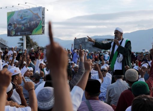 Seorang ustadz menyampaikan kajdian dan memimpin doa massal untuk Palu di pantai Talise. (Foto: Reuters/Al Jazeera)