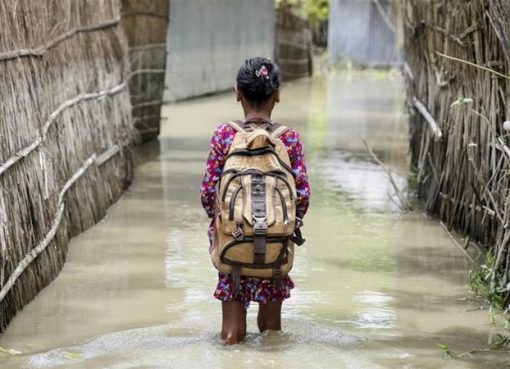 Seorang anak melintasi air (baanjir) dalam perjalanannya ke sekolah di distrik Kurigram, Bangladesh utara saat banjir pada Agustus 2016. (Foto: File Unicef/Al Jazeera)