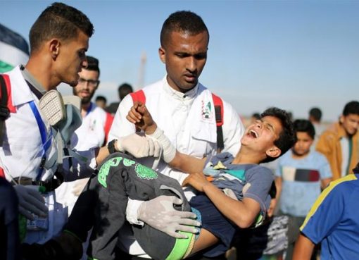 Seorang bocah lelaki Palestina yang terluka dievakuasi ketika protes di pagar Israel-Gaza masih berlangsung, Jumat (4/4). (Foto: Reuters/Al Jazeera)