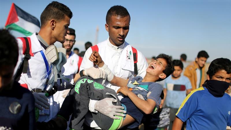 Seorang bocah lelaki Palestina yang terluka dievakuasi ketika protes di pagar Israel-Gaza masih berlangsung, Jumat (4/4). (Foto: Reuters/Al Jazeera)