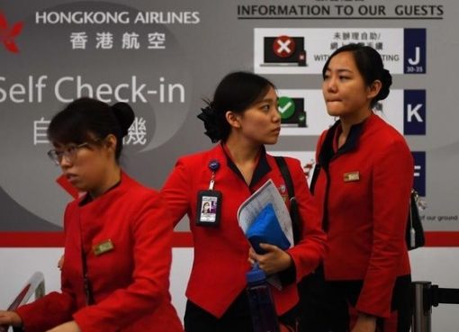 Staf maskapai menuju konter check-in setelah bandara Internasional Hong Kong dinyatakan kembali beroperasi Selasa (13/8). (Foto: AP/france24)