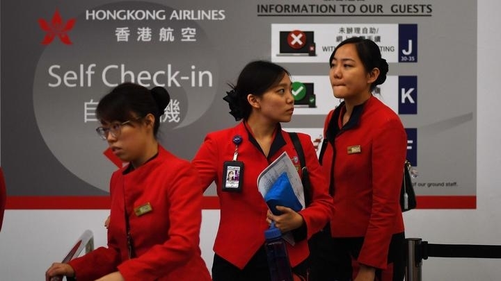 Staf maskapai menuju konter check-in setelah bandara Internasional Hong Kong dinyatakan kembali beroperasi Selasa (13/8). (Foto: AP/france24)