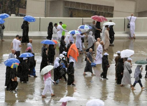 Hujan menguyrur umat Muslim saat menjalani ritual melempar jumrah, Senin (12/8) di Mina. (Foto: AFP/The National)