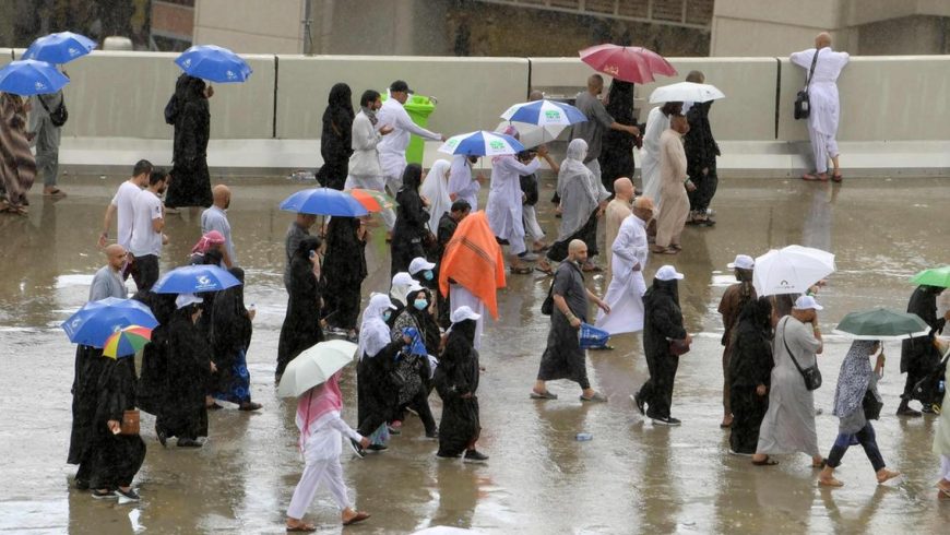 Hujan menguyrur umat Muslim saat menjalani ritual melempar jumrah, Senin (12/8) di Mina. (Foto: AFP/The National)