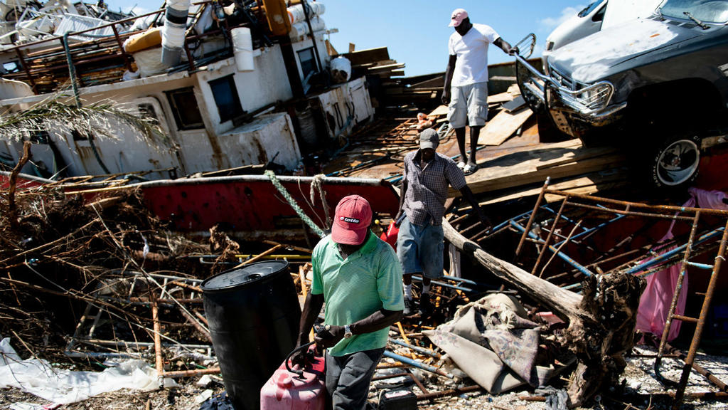 Orang-orang mendapatkan barang-barang dari kapal yang terdampar setelah Badai Dorian menerpa Kamis 5 September 2019 (Jumat WIB), di Pelabuhan Marsh, Abaco Besar. (Foto: AFP/Feaance24)