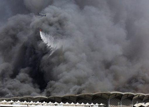 Helikopter pemadam kebakaran menyemprotkan air ke kobaran api di stasiun Haramain di Jeddah. (Foto: AP/Arab News)