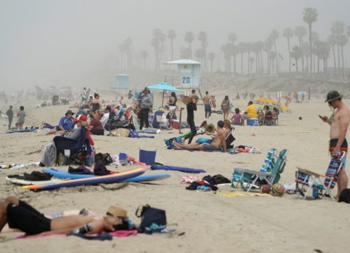 Orang-orang duduk berkelompok di Huntington City Beach di tengah mewabahnya penyakit coronavirus di Huntington Beach, California, AS. Gubernur California Gavin Newsom mendesak orang-orang yang mengunjungi pantai untuk mempraktikkan jarak sosial.(Foto: Reuters/Al Jazeera)