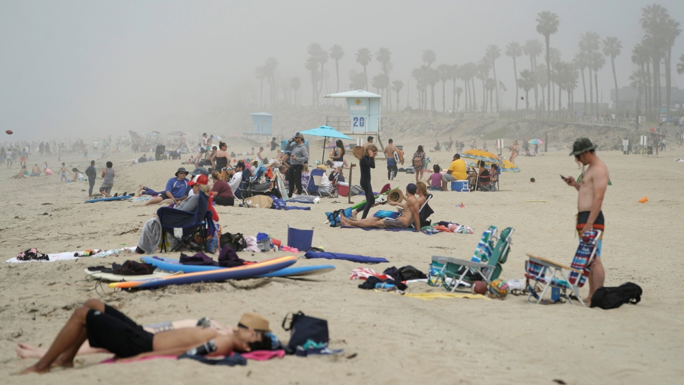 Orang-orang duduk berkelompok di Huntington City Beach di tengah mewabahnya penyakit coronavirus di Huntington Beach, California, AS. Gubernur California Gavin Newsom mendesak orang-orang yang mengunjungi pantai untuk mempraktikkan jarak sosial.(Foto: Reuters/Al Jazeera)