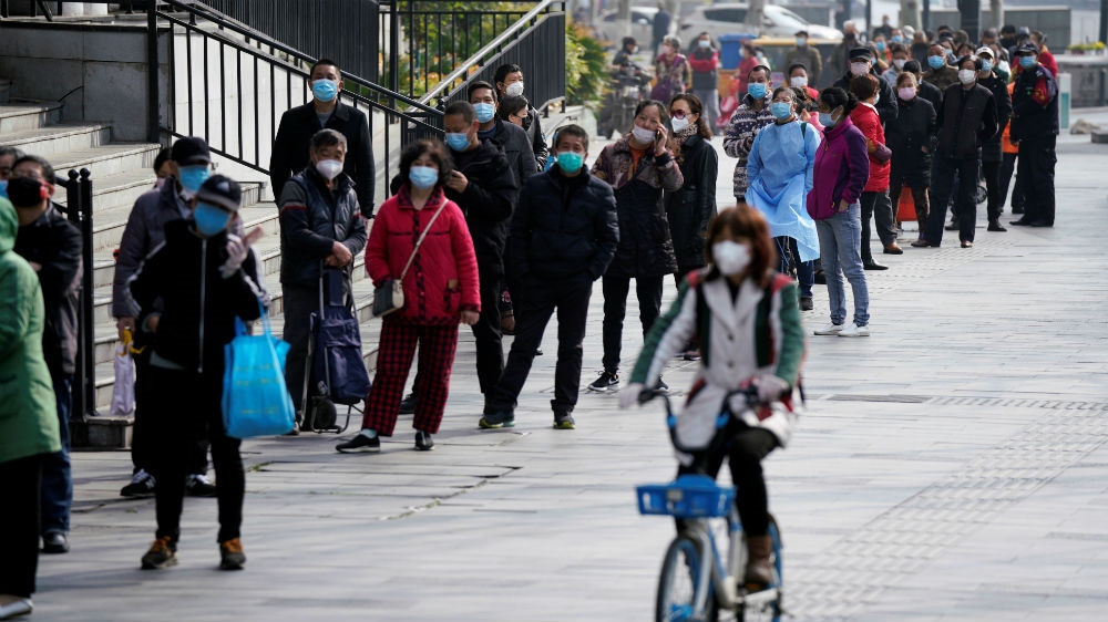 Orang-orang mengantri untuk memasuki supermarket di Wuhan, China, ketika kehidupan perlahan kembali normal di kota itu: (Foto: Reuters/Al Jazeera)