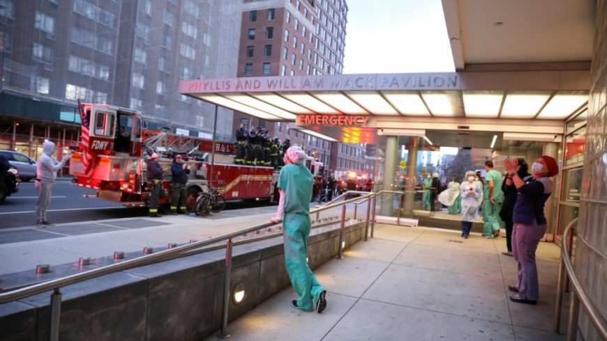 Pekerja medis bereaksi terhadap tepuk tangan dari petugas pemadam kebakaran dan anggota masyarakat di New York City pada hari Jumat atas kerja keras mereka membantu pasien virus corona.(Foto: Reuters/l Jazeera)