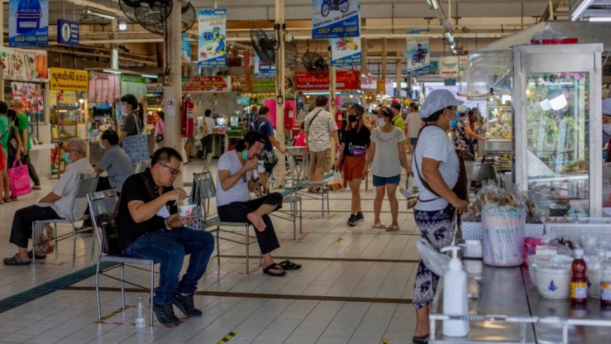 Orang-orang berupaya menjaga jarak sosial duduk dan makan di sebuah pasar di Bangkok, setelah pembatasan dilonggarkan minggu ini.(Foto: AP/Al Jazeera)