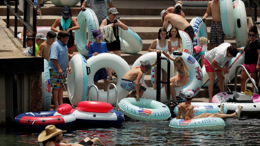 Sejumlah orang, termasuk anak-anak, bersiap mengarungi Sungai Comal di Texas meskipun terjadi lonjakan baru-baru ini dalam kasus COVID-19. (Foto AP/Al Jazeera)