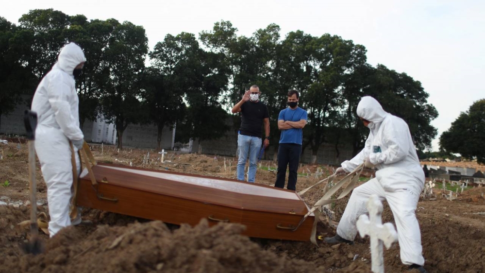 Dua bersaudara Carlos Alexandre dan Wagner Cardninot, menghadiri pemakaman ayah mereka, Jose Herminio de Farias, 76 tahun, Sabtu lalu, yang meninggal karena COVID-19 di Rio de Janeiro, Brazil. (Foto Reuter/Al Jazeera)