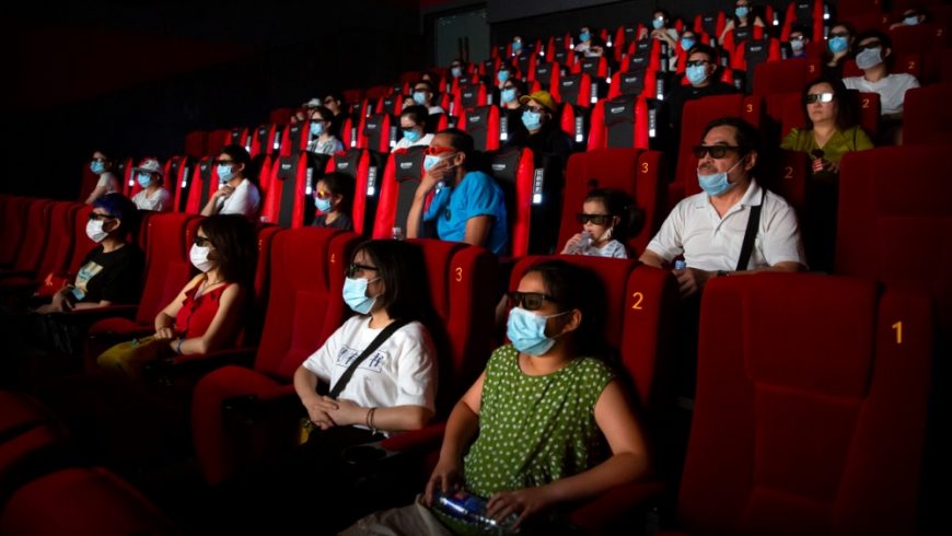 Dengan memakai masker wajah untuk melindungi diri dari virus corona, penonton di Beijing bisa menikmati film di bioskop. Ibukota China itu membuka kembali bioskop di beberapa bagian kota yang dianggap berisiko rendah.(Foto AP/Al Jazeera)