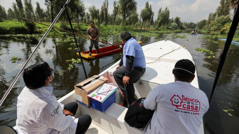 Petugas kesehatan Meksiko dengan menggunakan perahu di kanal di Xochimilco dalam perjalanan untuk mengumpulkan sampel dari pintu ke pintu untuk menguji COVID-19, di Mexico City. (Foto AP/Al Jazeera)