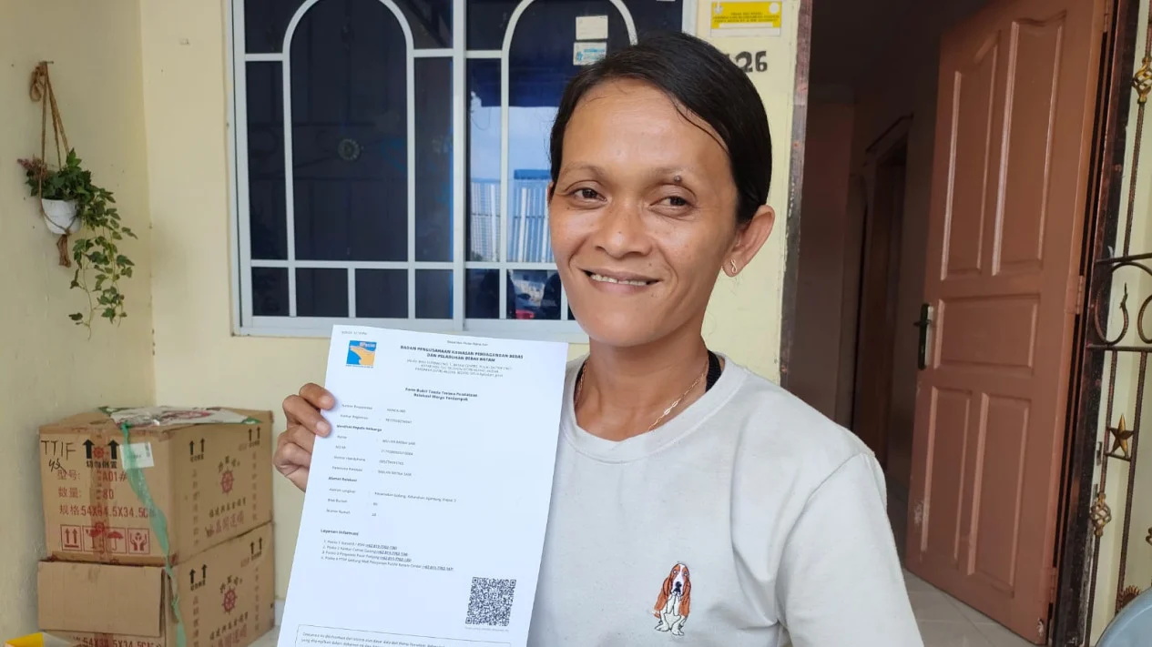 Warga Rempang, Wulan, menunjukan dokumen berita acara serah terima dari BP Batam.