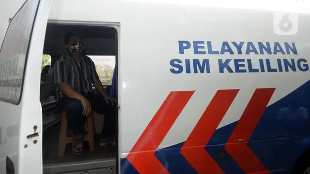 Warga duduk dalam mobil saat mengurus SIM di Pelayanan SIM Keliling.