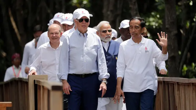 Presiden Indonesia Joko Widodo atau Jokowi (kanan) memberi isyarat di samping Presiden Amerika Serikat Joe Biden, Kanselir Jerman Olaf Scholz, Perdana Menteri India Narendra Modi, dan para pemimpin dunia lainnya pada acara penanaman mangrove di sela-sela pertemuan KTT G20 di Taman Hutan Raya Ngurah Rai, Denpasar, Bali, Indonesia, Rabu (16/11/2022).