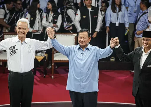 Tiga Calon Presiden, Ganjar Pranowo, Prabowo Subianto dan Anies Baswedan (kiri ke kanan) mengangkat tangan usai debat perdana Pilpres 2024 di halaman Gedung Komisi Pemilihan Umum (KPU), Selasa (12/12/2023).